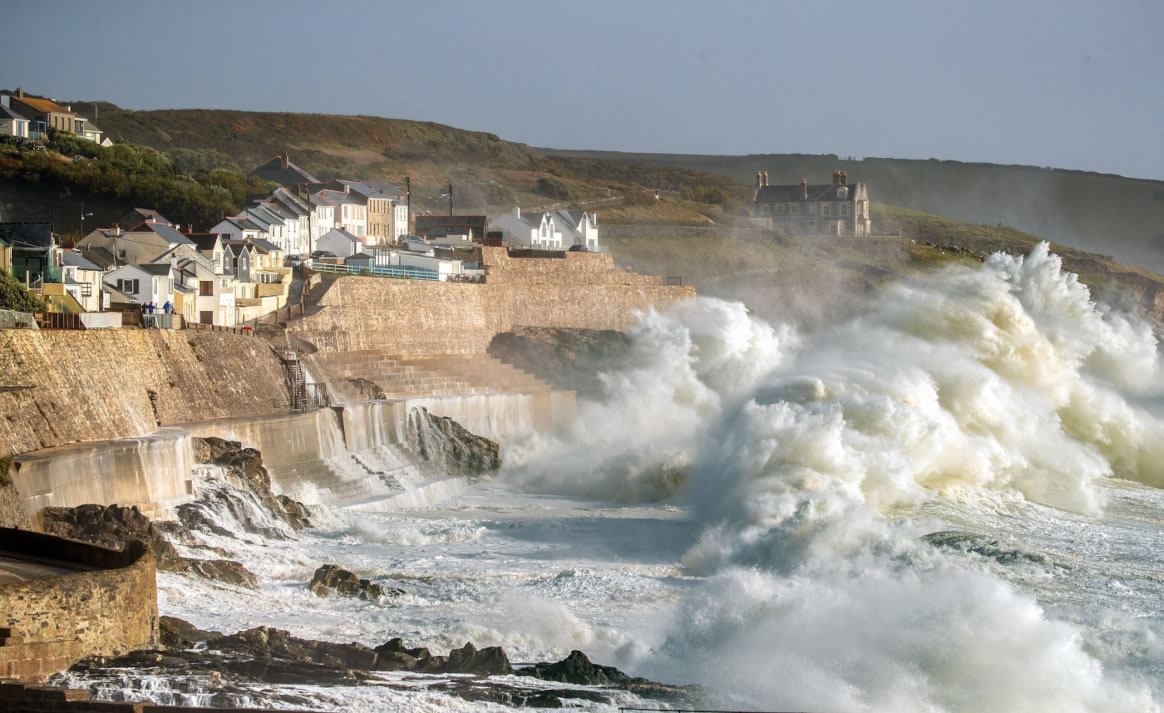 Picture of Porthleven on a stormy day with waves hitting the coastal wall defenses, Cornwall